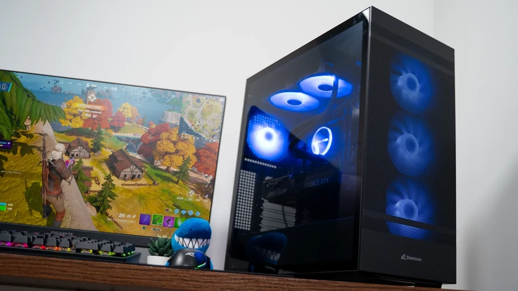 PC ALTERNATE Gamer Starter avec ventilateurs bleus à côté d'un moniteur gaming