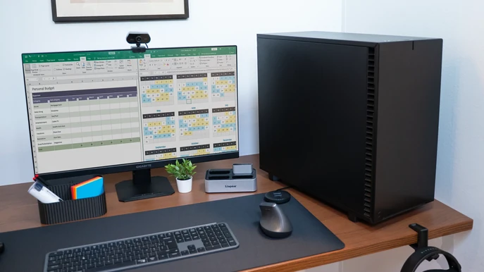 ALTERNATE Workstation Pro sur bureau avec moniteur, tableurs Excel et webcam
