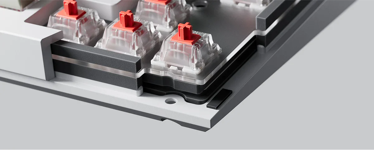 Gros plan de switches mécaniques rouges Keychron montées dans une base de clavier hot-swap argentée