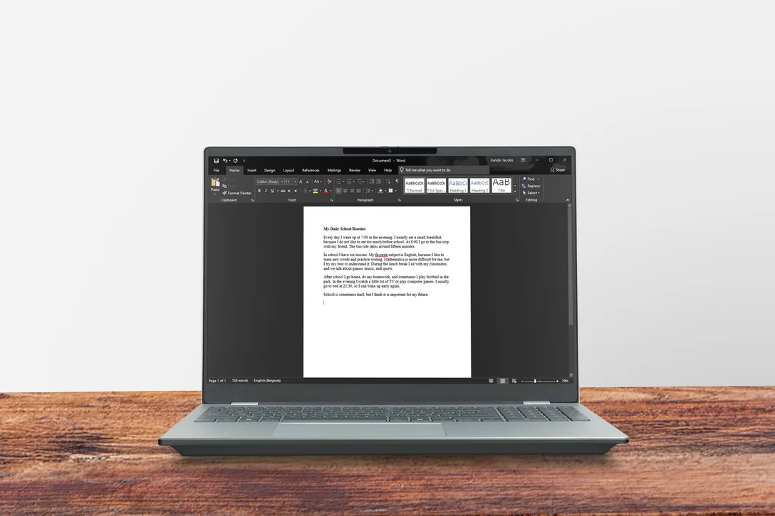 PC portable sur un bureau en bois avec un travail scolaire ouvert dans Word