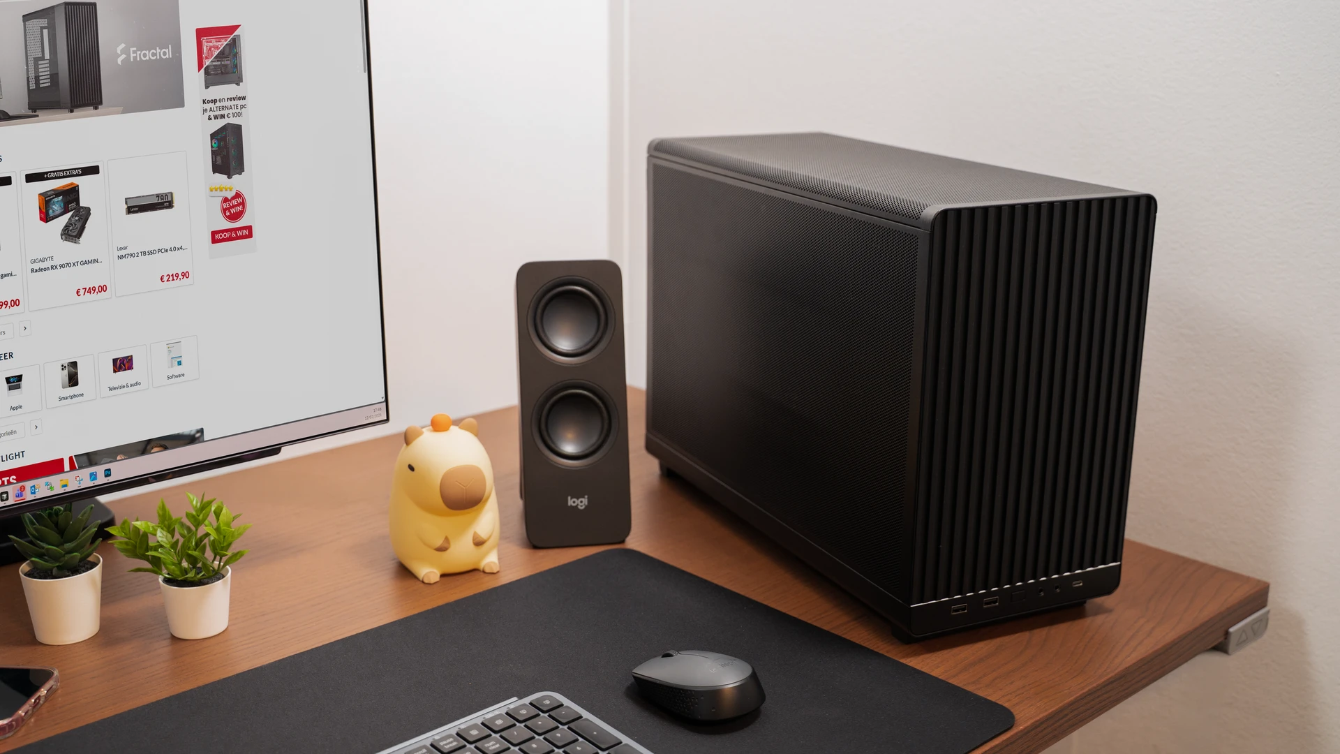 PC compact noir avec panneau avant en bois sur un bureau